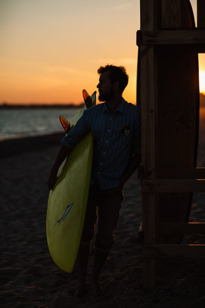 Happy surfers couple standing with surfboards on the sandy beachの写真素材