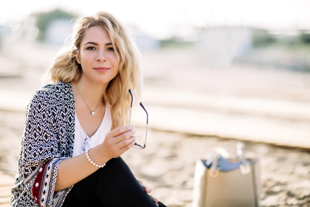 Blonde girl on the beach of the sandy beach by the sea.の写真素材