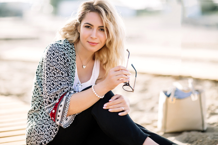 Blonde girl on the beach of the sandy beach by the sea.の写真素材