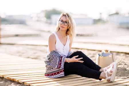 Blonde girl on the beach of the sandy beach by the sea.の写真素材