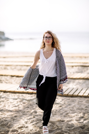 Blonde girl on the beach of the sandy beach by the sea.の写真素材