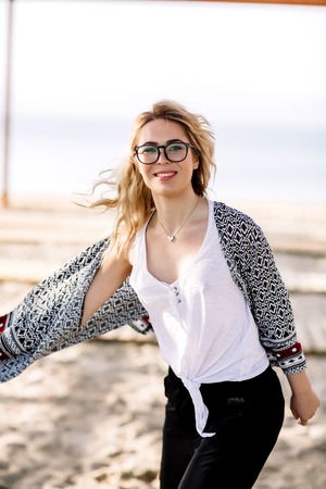 Blonde girl on the beach of the sandy beach by the sea.の写真素材