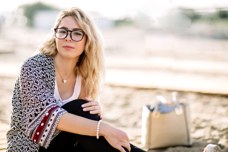 Blonde girl on the beach of the sandy beach by the sea.の写真素材