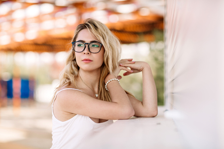 Beautiful girl, blond in a white long T-shirt on the beach on a sunny day.の写真素材