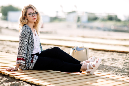 Blonde girl on the beach of the sandy beach by the sea.の写真素材