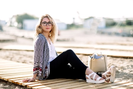 Blonde girl on the beach of the sandy beach by the sea.の写真素材