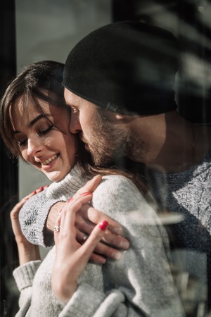 Portrait beautiful couple in stylish clothes in gray tones, cityの写真素材