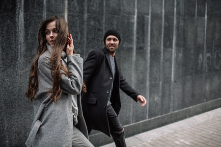 Beautiful couple in stylish clothes in gray tones, cityの写真素材