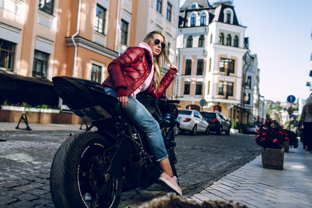 Young beautiful sexy brunette sitting on a black motorcycleの写真素材