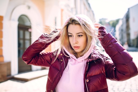 Stylish hipster girl in the retro jeans suit posing in front of old building.の写真素材