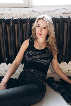Portrait of a beautiful fashion woman, blonde, jeans, gray backgroundの写真素材