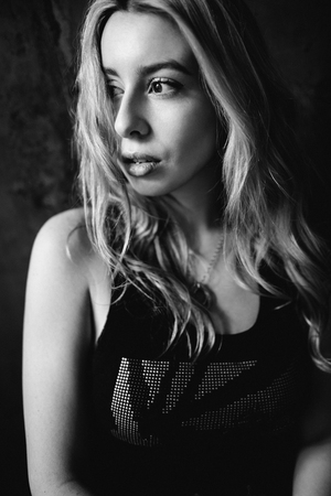 Portrait of a beautiful fashionable woman, blonde, jeans, brown backgroundの写真素材