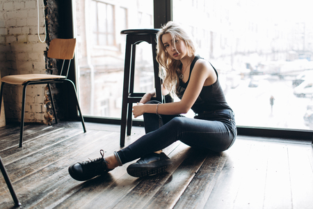 Portrait of a beautiful fashion woman, blonde, jeans, gray backgroundの写真素材