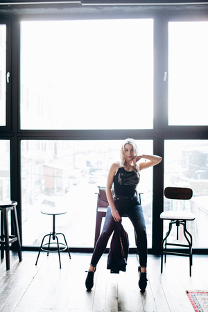 Portrait of a beautiful fashion woman, blonde, jeans, gray backgroundの写真素材