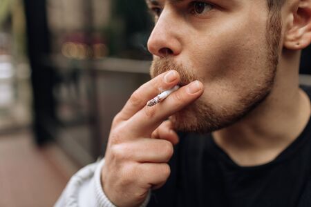 man smokes a cigarette. The spread of cigarette smoke. mustacheの写真素材