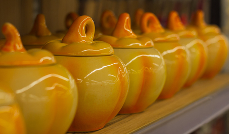 Ceramic clay pots in the form of pumpkin for preparation hot on the shelf in a rowの写真素材