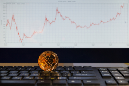Bitcoin on black keyboard one coin gold color in the chart backgroundの写真素材