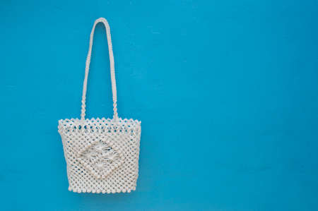 A traditional knitted shopping bag on a blue concrete floor. Eco friendly zero waste bag. Close-up. Needlework. Ecological stuff for home. Copy space.の写真素材