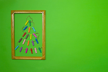 A creative Christmas tree made of wooden multi-colored clothespins strung on a shaggy rope....