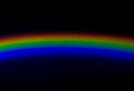 An arc made of decomposed light on a dark background. Light spectrum.