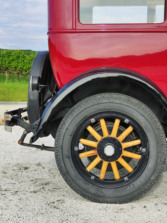 Red rarity vintage car. Back wheel and part of an old car close-up. Travel, tourism. Vertical photo.
