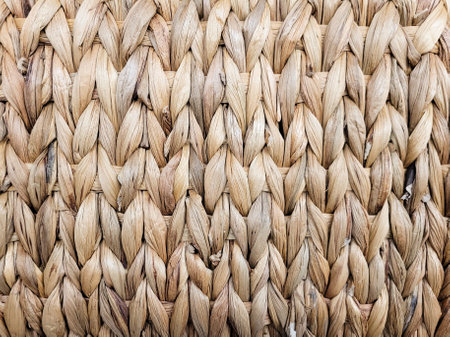 Texture of a wicker basket made of natural fibers. Handmade product, craft. A fragment of a traditional pattern knitted from dry grass. Close-up. Cloth made of rough, hard material. Rustic background.の写真素材