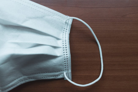 Corona virus prevetion face mask protection. Medical surgical masks on a desk. Wood background.