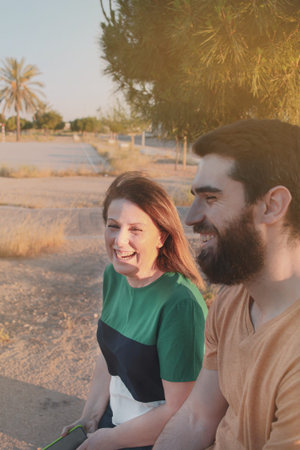 Two people (mother and son in law) smiling outdoors at sunset.