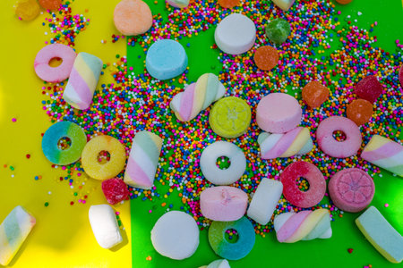 gummies and colorful candies in green background