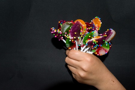 BOUQUET OF SWEET LOLLIPOPS ON BLACK BACKGROUNDの写真素材
