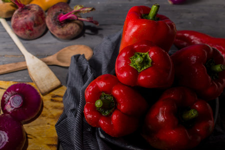 STILL LIFE WITH OVERHEAD VIEW OF RED PEPPERS ON A RUSTIC WOODEN TABLE DECORATED WITH OLD CLOTH AND DRIED PUMPKINSの写真素材