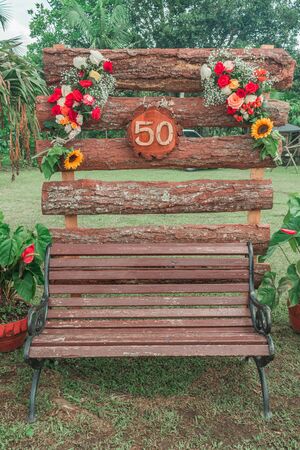 country floral decoration with number 50 on rustic wooden boards and wooden chair belowの写真素材