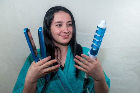 YOUNG WOMAN AFTER GETTING OUT OF THE SHOWER WITH A HAIR STRAIGHTENER AND A LAUGH WITH AN EXPRESSION...