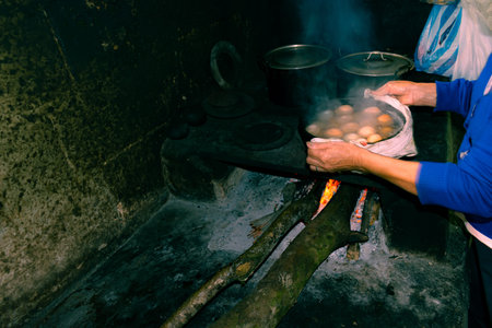 hands of a latin peasant woman cooking on a wood stove