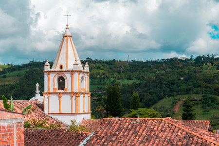 tower of the church of the town of ocamonte in colombia with rooftops and mountain in the backgroundの写真素材