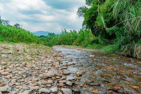 landscape of a river in dry season and mountains in the background and stones on the side