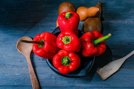 fresh red peppers just harvested and dried pumpkins on old wood