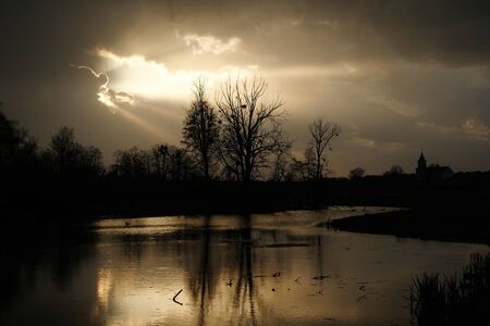 The day begins. Beautiful landscape with church and lakeの写真素材