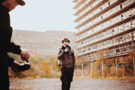 Curly man filming friends at sunset on phoneの写真素材