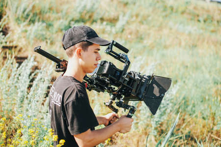 Operator with professional camera in green plainの写真素材