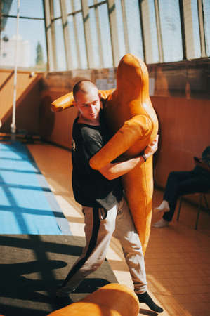 Bold Young man drugs mannequin in gym.の写真素材