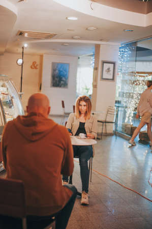 Sexy blonde woman ogle to bald man in cafeの写真素材