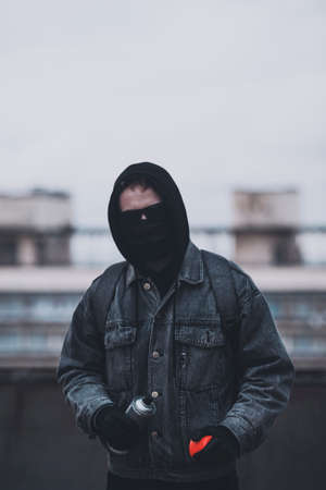 Young man who hides his face preparing to make graffiti. Urban viewの写真素材