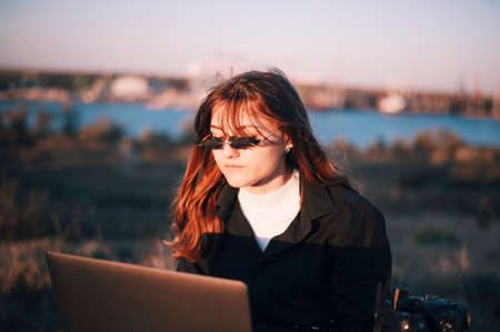 Girl in funny glasses works on laptopの写真素材