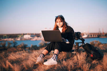 Cameragirl with laptop in industrial zoneの写真素材