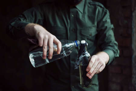 Dangerous bandit soak a wick of molotov cocktail with a fuelの写真素材