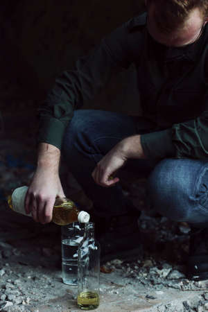 Young soldier mix ingredients to make molotov cocktailの写真素材