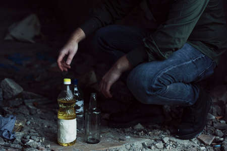 Post Apocalypse scene of preparing molotovs cocktail in desert buildingの写真素材