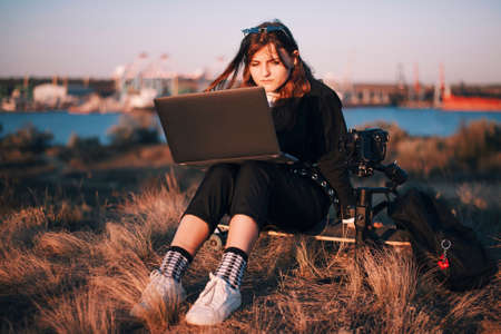 Girl works on laptop near the cameraの写真素材