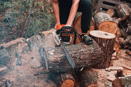 Man saw a big log with chainsaw.の写真素材